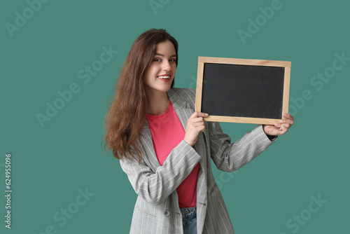 Female teacher with chalkboard on green background