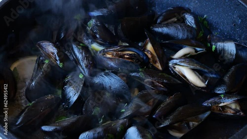 cooking, mussels with garlic and lemon in a frying pan, close up photo