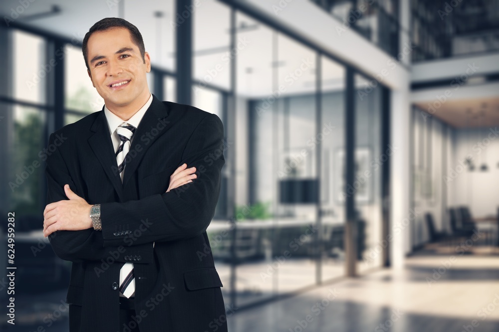 Young happy business man with arms crossed at office Young happy business man with arms crossed at office