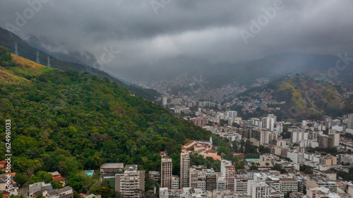 Aerial view of Rio de Janeiro on a cloudy day, in the neighborhoods of Tijuca and adjacencies and green areas such as the Tijuca National Park. In the background, Maracanã stadium and Guanabara Bay.