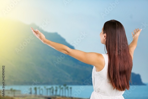 Happy young tourist woman raising arms