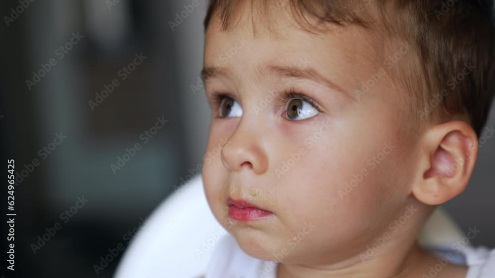 Face of a naughty toddler refusing to eat. Persistent mom manages to give food to her son. Close up portrait. Face of a naughty toddler refusing to eat. Persistent mom manages to give food to her son. Close up portrait.