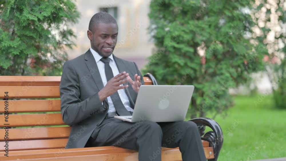 Online Video Chat by African Businessman on Laptop Outdoor Online Video Chat by African Businessman on Laptop Outdoor