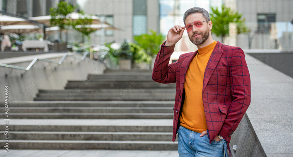 man in menswear in the street, copy space. man in menswear outside.