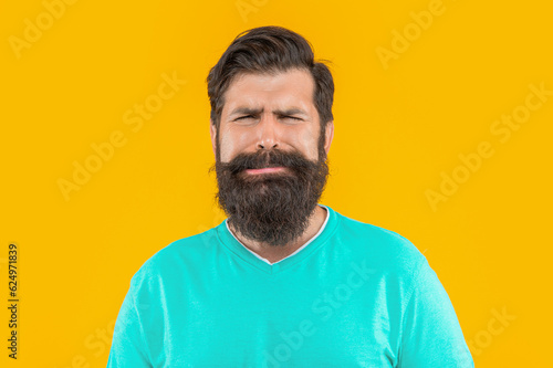 portrait of upset bearded guy in studio. portrait of bearded guy on background.
