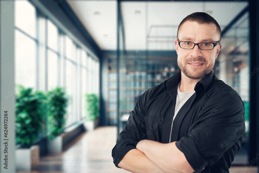 Young happy business man with arms crossed at office Young happy business man with arms crossed at office