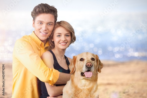 Happy young couple with cute dog at the beach