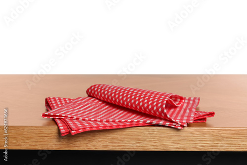 Checkered tablecloth on wooden table against white background