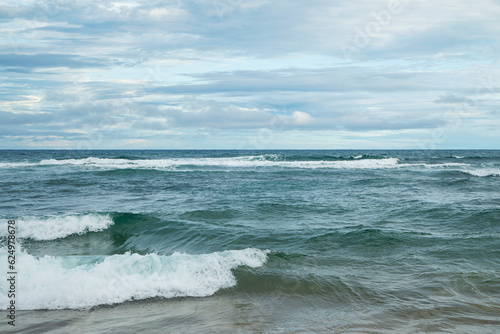 Vastid  o do oceano com ondas no litoral do Brasil em uma tarde com nuvens. 