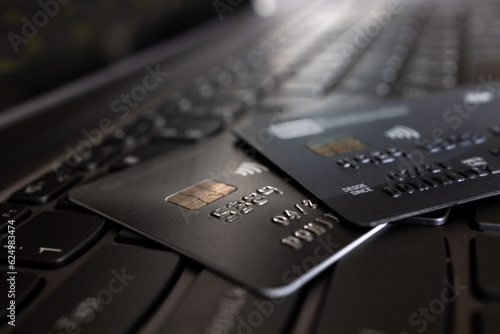 Credit cards over laptop keyboard closeup selective focus