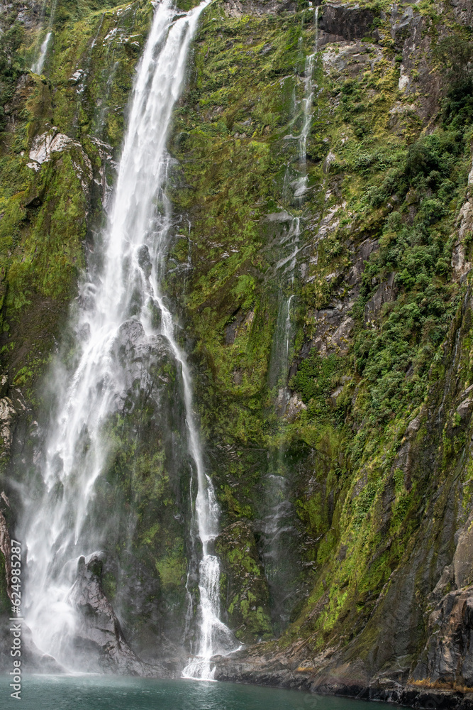 Cruising in a large catamaran past Mitre Peak and many waterfalls through the Milford Sound Cruising in a large catamaran past Mitre Peak and many waterfalls through the Milford Sound