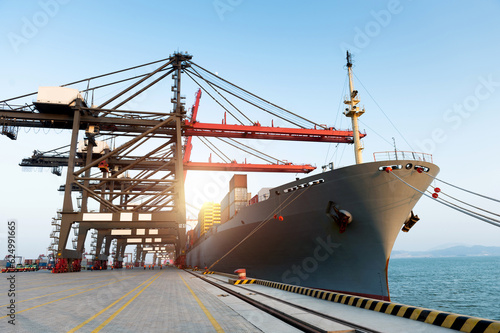 Obraz na płótnie Container cargo freight ship with working crane bridge in the port