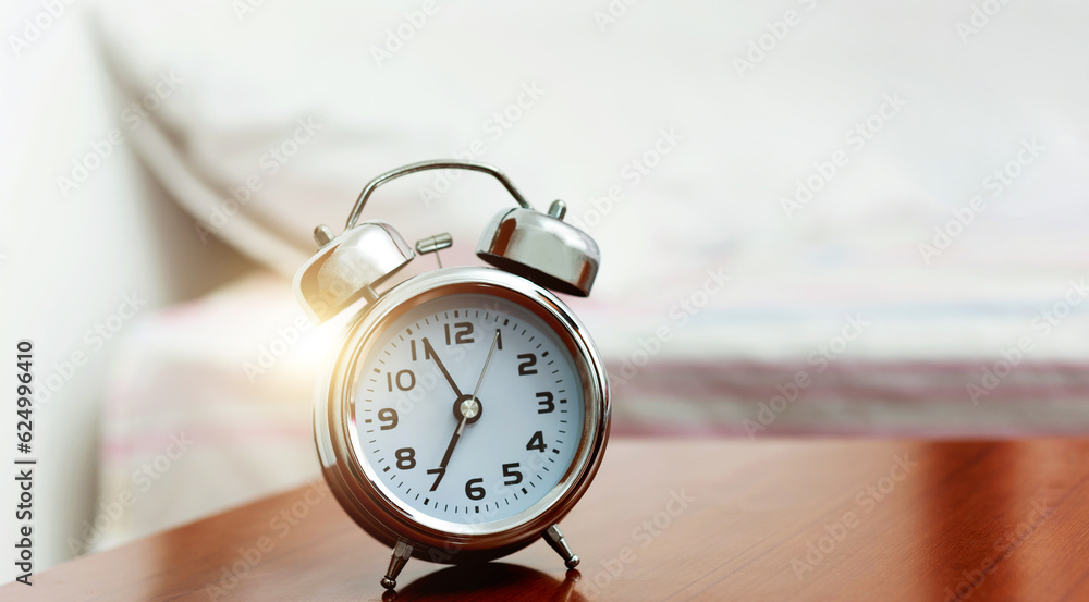Single alarm clock on night table at bed Single alarm clock on night table at bed