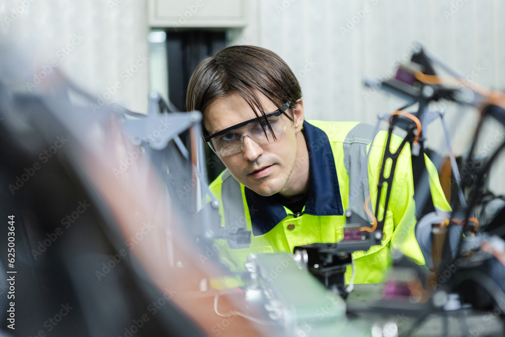 Male technician engineer checking automation robotics at industrial modern factory. man working at factory innovation automation robot. technical professional operation. Male technician engineer checking automation robotics at industrial modern factory. man working at factory innovation automation robot. technical professional operation.