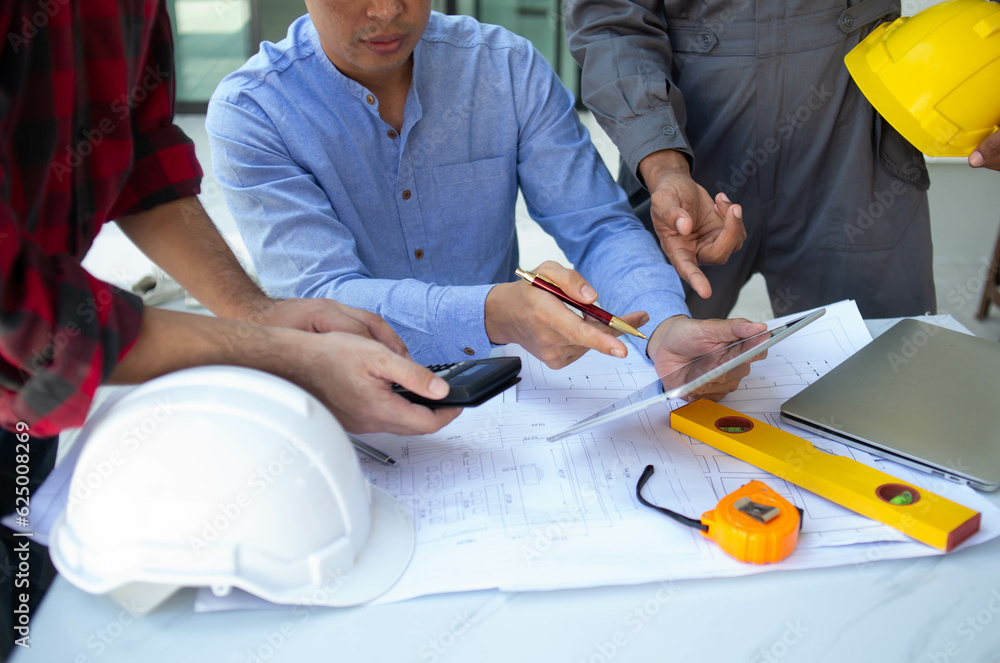 © weerachai - Team Engineer and Architect planing and discuss at Construction Site with blueprint