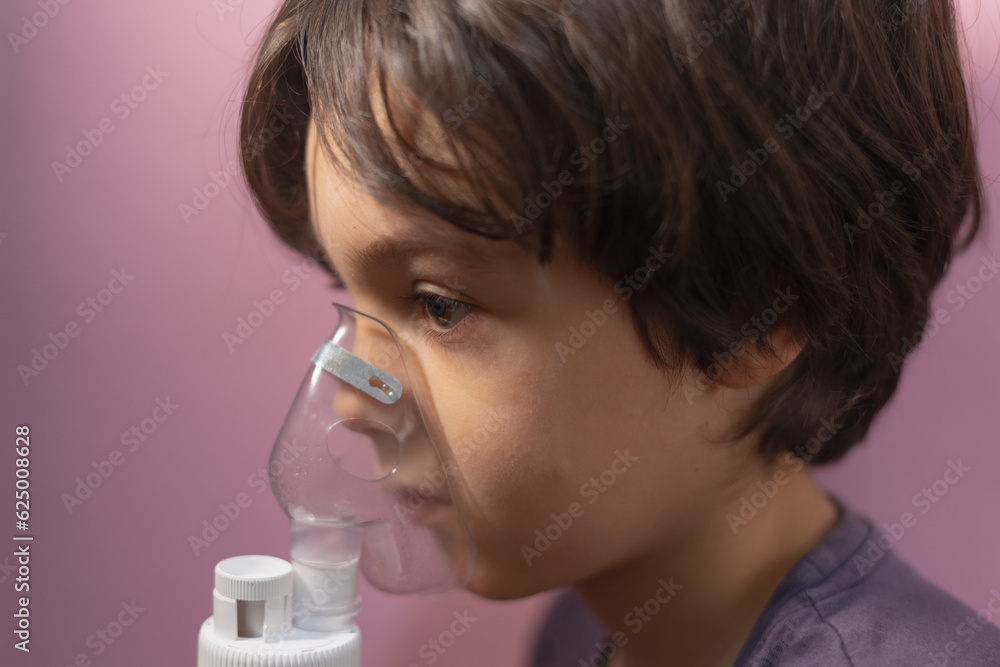 the child does inhalation, the boy inhales the medicine through the mask the child does inhalation, the boy inhales the medicine through the mask