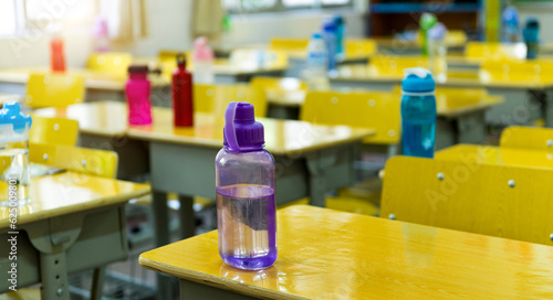 Bottles of water on desk in classroom