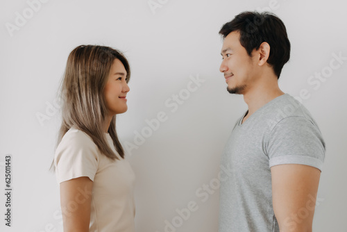 Happy smiling asian couple standing isolated on white background.