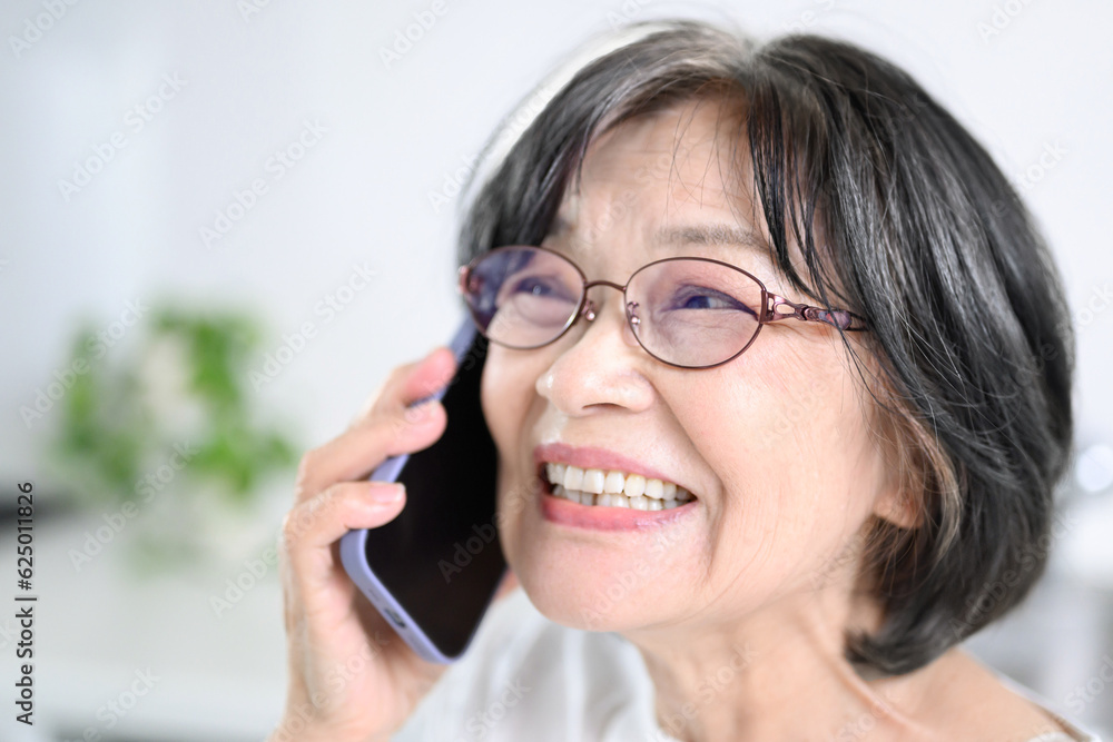 笑顔で電話をするアジア系(日本人)高齢者笑顔のアップ 笑顔で電話をするアジア系(日本人)高齢者笑顔のアップ