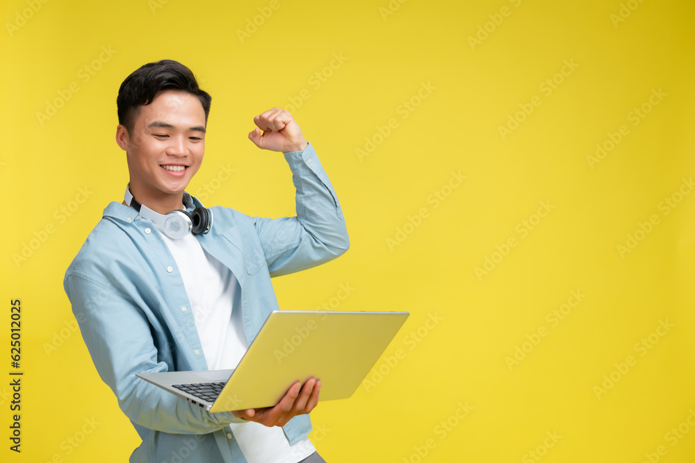 young overjoyed man walking going hold use work on laptop do winner's gesture clenched fist isolated young overjoyed man walking going hold use work on laptop do winner's gesture clenched fist isolated