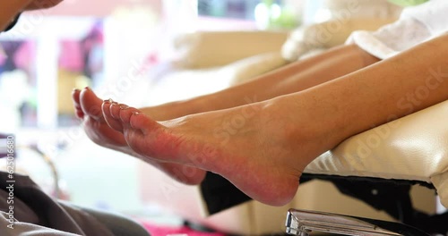 manicure artist making foot nail polishing with brush and tools at beauty salon