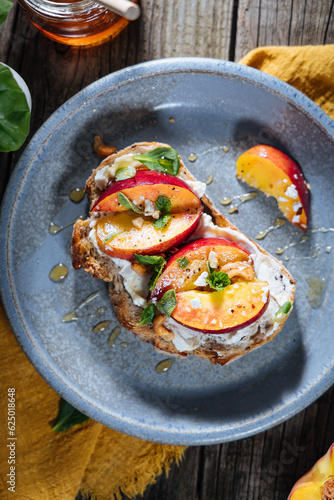 Spread with cream cheese on bread with rucola, nuts and peach. Healthy summer brunch. Vitamins and minerals