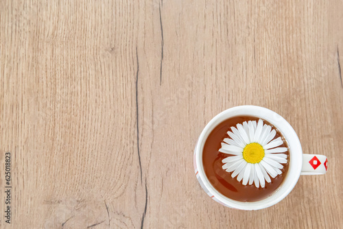 Chamomile tea in a mug on a wooden background. Place for text  copy space  blank for background design