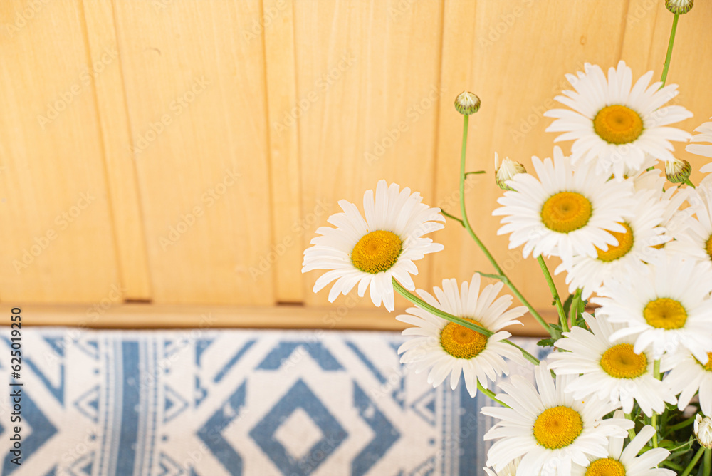 Obraz premium SSummer bouquet of delicate daisies on the background of a wooden wall wall. Postcard for Mother's Day or March 8. Idea for a postcard, congratulations. copy space