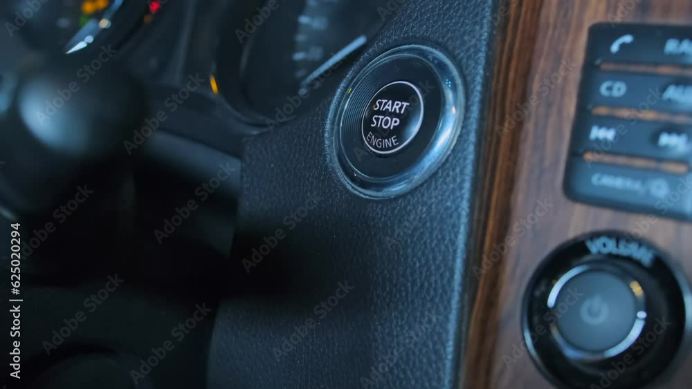 Short video finger pressing a button to start a car engine, side view