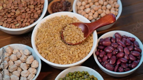 Legumes, lentils, chickpeas, bulgur and beans assortment. Rotation top view. 4K