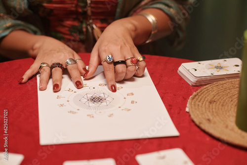 Closeup image of astrologer examining natal chart of client to check love compatibility of her and her partner