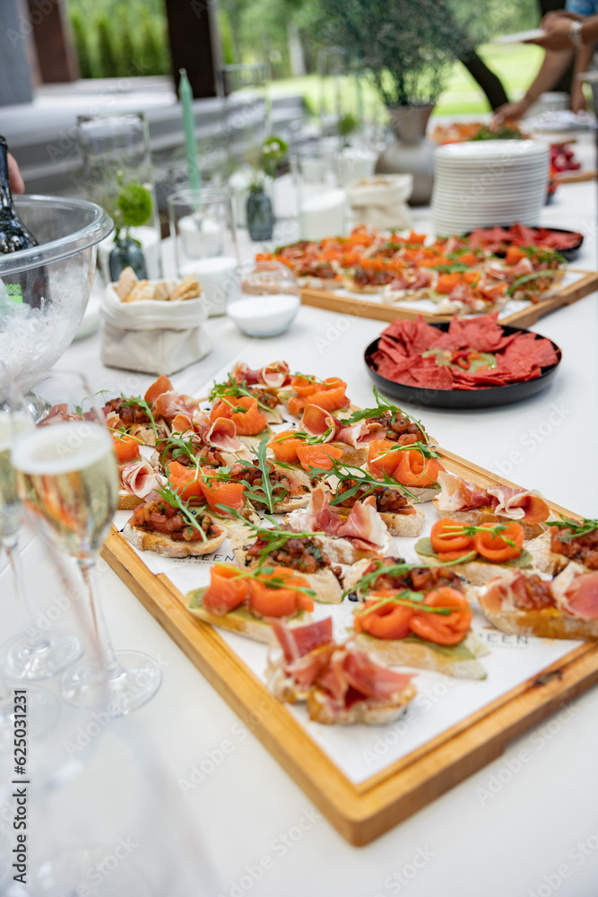 Bruschetta snacks, cheese with sausages, pate. A festive table for a company of people with many different dishes.