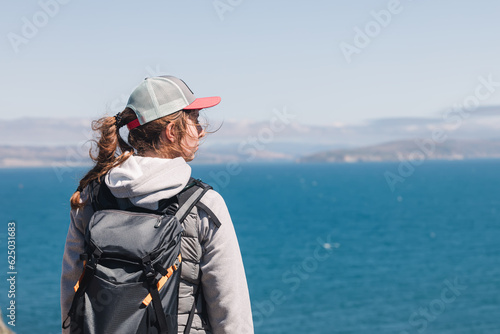 Woman looking to the blue ocean on windy day