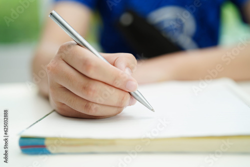 Asian teenage student write homework, study lesson for exam online learning education.
