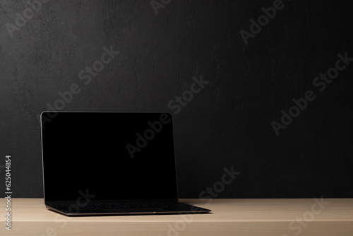 Laptop with blank screen on wooden table © karandaev