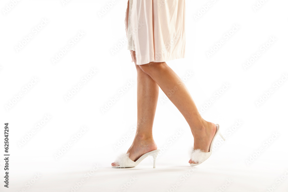 Female legs with hill shoes wearing a camisole. White background Female legs with hill shoes wearing a camisole. White background
