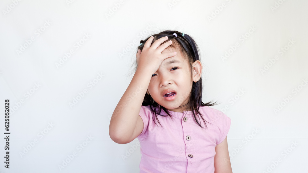 Frustrated cute Asian child girl wearing pink casual holding on forehead being depressed regretting what he did having headache, looking stressful. Frustrated cute Asian child girl wearing pink casual holding on forehead being depressed regretting what he did having headache, looking stressful.