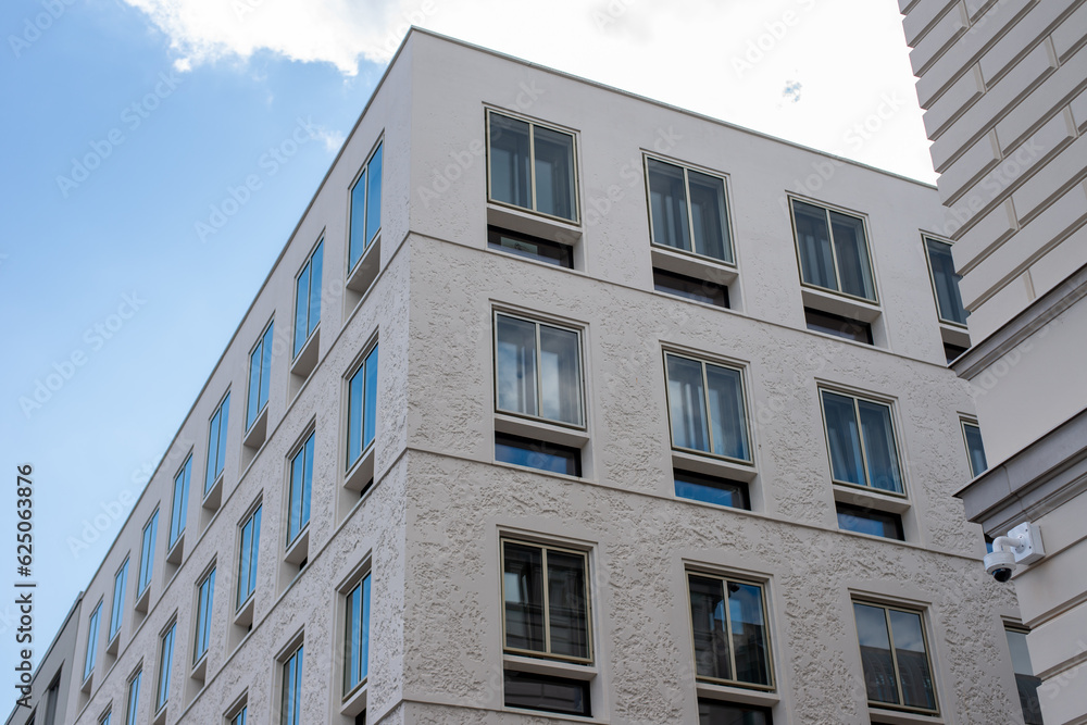 modern facade decorated with textured plaster with selected non-textural frames around windows