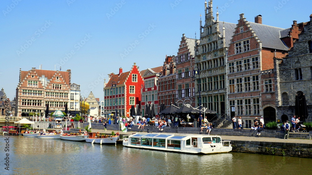 malerischer Hafen in Gent mit Anlegesteg am Kanal für Touristenboote vor mittelalterlichen Handelshäusern