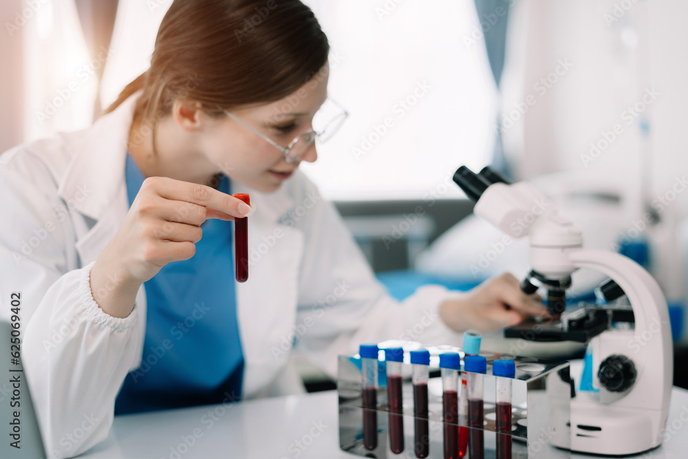 Doctor taking a blood sample tube from a rack with machines of analysis in the lab background, Technician holding blood tube test in the research laboratory. Doctor taking a blood sample tube from a rack with machines of analysis in the lab background, Technician holding blood tube test in the research laboratory.