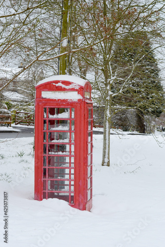 A red telephone box in the snow