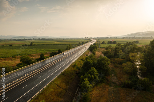 Aerial panoramic photo from above with A1 highway road between Sebes and Deva. Drone photo with the roads of Romania. Aerial view during sunset after a summer storm.