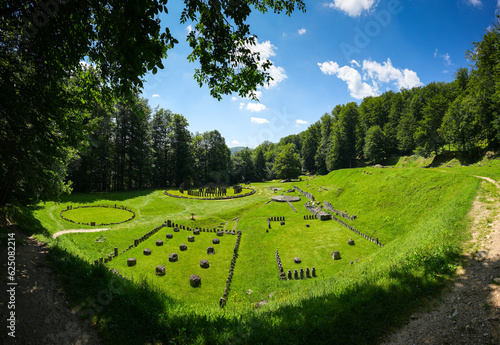 Sarmizegetusa Regia historical landmark in Romania. Wide angle photo during a sunny day in the middle of green forest Orastiei Mountains. Landmarks of Romania. photo