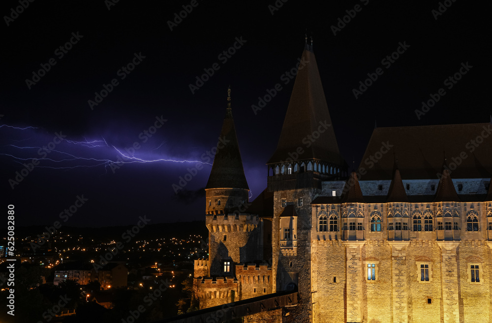 Summer thunderstrike storm at the medieval architecture Corvin (Hunyad) Castle in Hunedoara. Wide photo thunderstorm sky over Corvinilor Castle (in Romanian language).