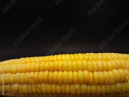Closeup steamed sweet corn with yellow color without corn husk single isolated on black background