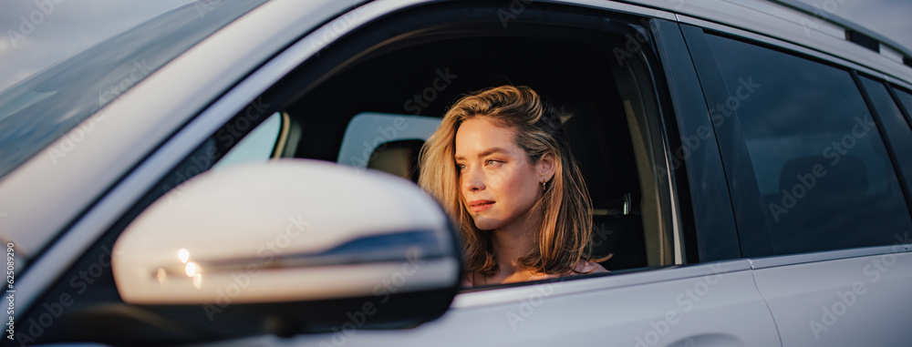 Fototapeta premium Happy woman driving her new electric car.