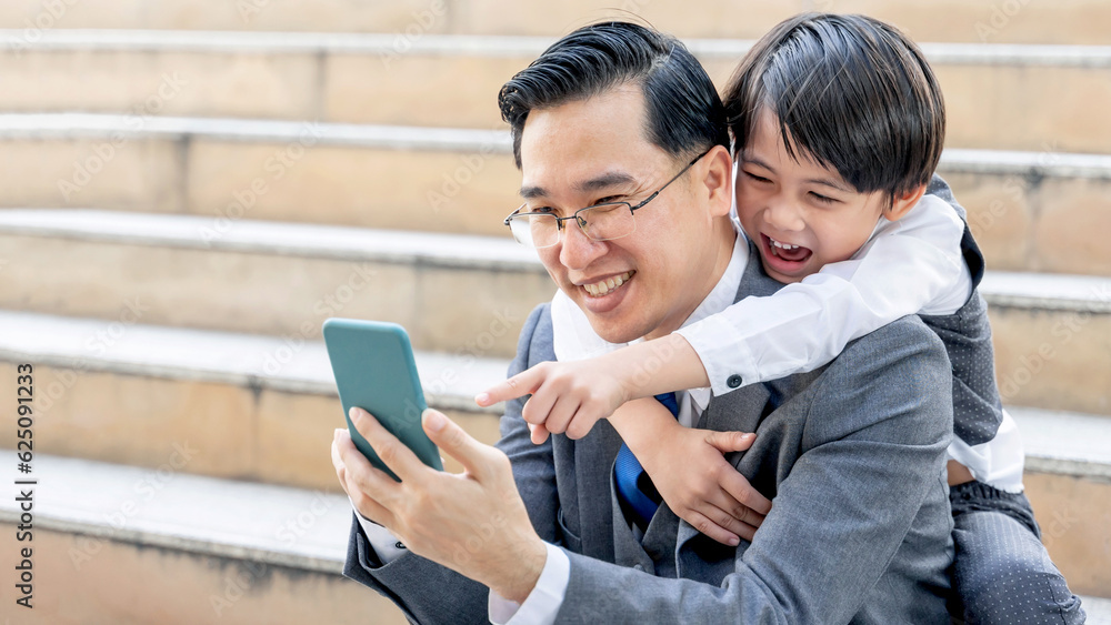 Father and son playing smart phone together on business district urban, Dad and Son happy Asian family concept Father and son playing smart phone together on business district urban, Dad and Son happy Asian family concept
