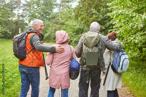 Elderly couples hiking together in forest during vacation