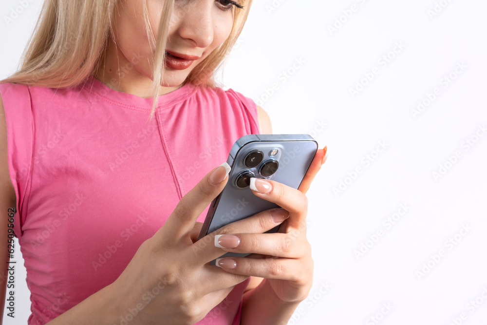 Close up shot of blonde caucasian girl in sleeveless pink shirt using her smartphone. Chatting, messaging, scrolling, browsing, social media, beautiful hand and nails. People lifestyle concept. Close up shot of blonde caucasian girl in sleeveless pink shirt using her smartphone. Chatting, messaging, scrolling, browsing, social media, beautiful hand and nails. People lifestyle concept.