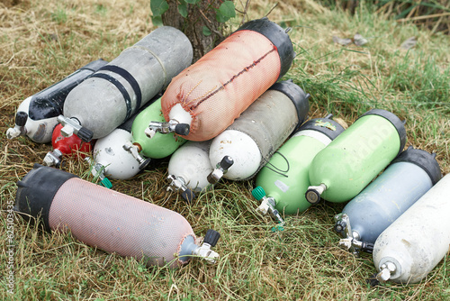 Many gas cylinders for scuba diving lie on the grass, concept active lifestyle, extreme sports